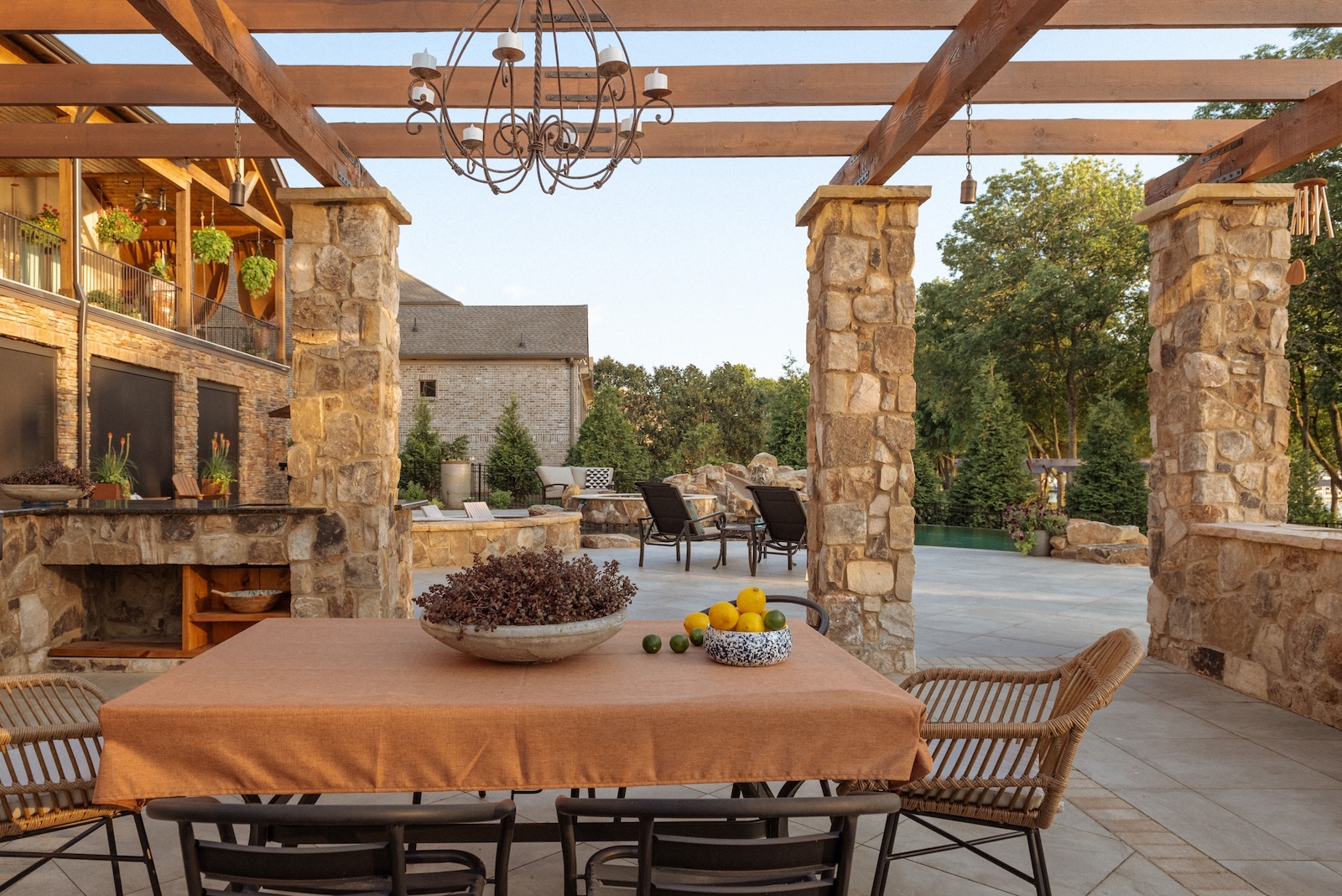 Custom Outdoor Living Area Set in Stone With Fruit-Adorned Table, Seating | Milosi Nashville Landscaping