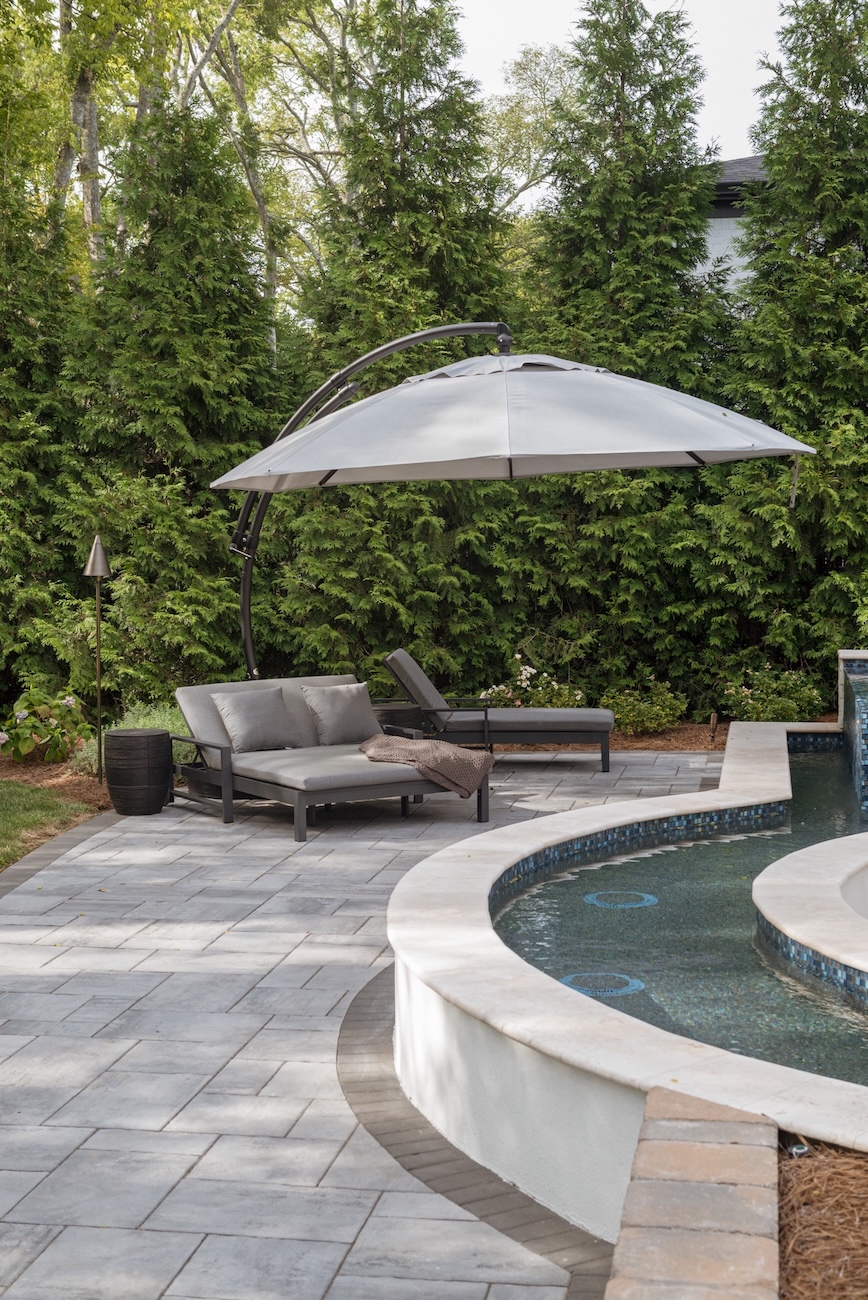 Corner Custom Patio, Lounge Chairs, Umbrella & Pool Edge | Milosi Nashville Landscaping