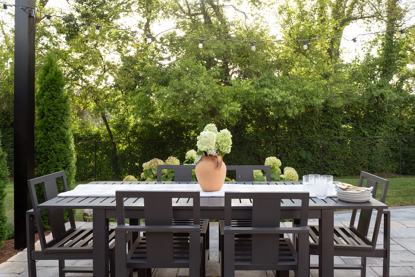 Modern Patio Dining Set with Hydrangeas, Tableware, Framed by Trees, Fending | Milosi Nashville Landscaping