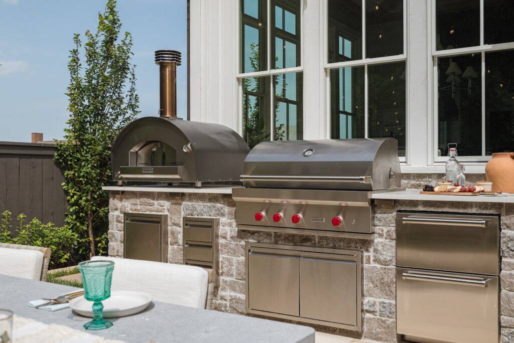 Fully Equipped Outdoor Kitchen and Set Patio Set in Front of House Windows | Milosi Nashville Landscaping