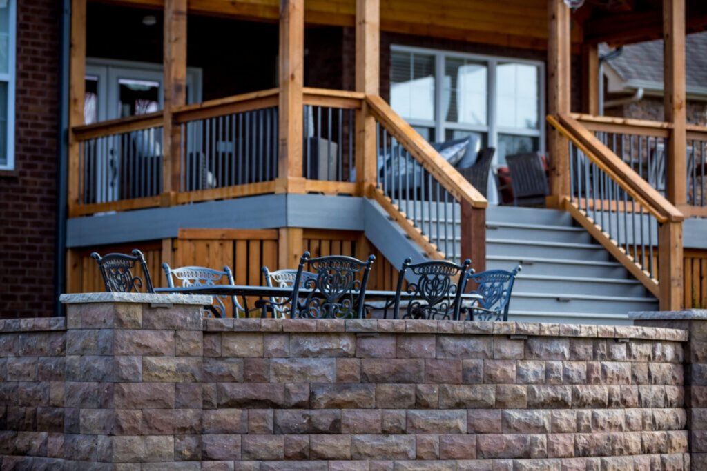 Milosi Landscaping Curved, Stone Retaining Wall Creates a Terrace for Outdoor Dining