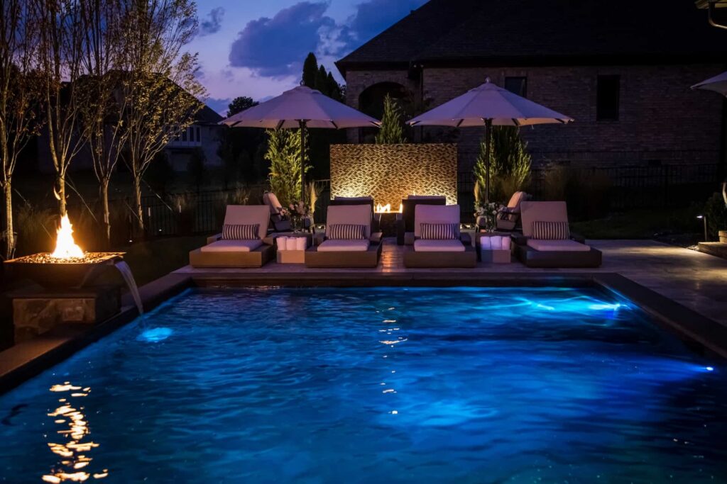 Beautifully Lit Pool with Custom Water and Fire Features and Lounge Seating by Milosi Landscaping in Nashville