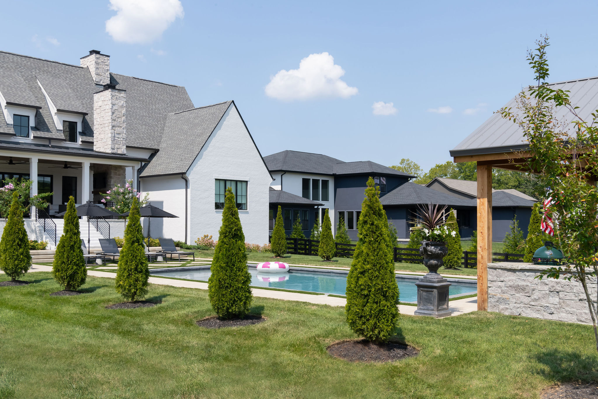 Well landscape trees in foreground with custom pool in the background.