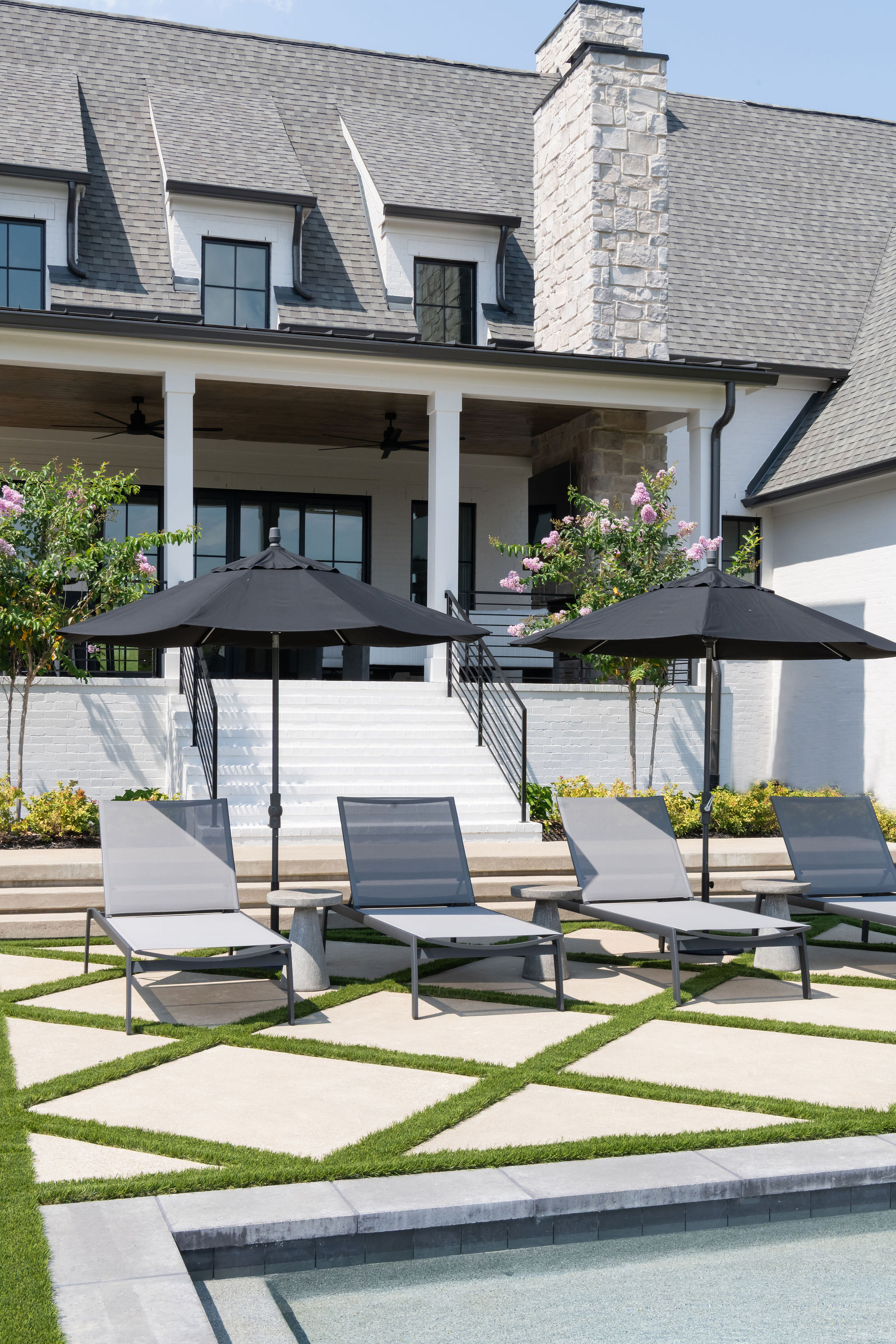 Patio furniture on pavers overlooking custom pool.
