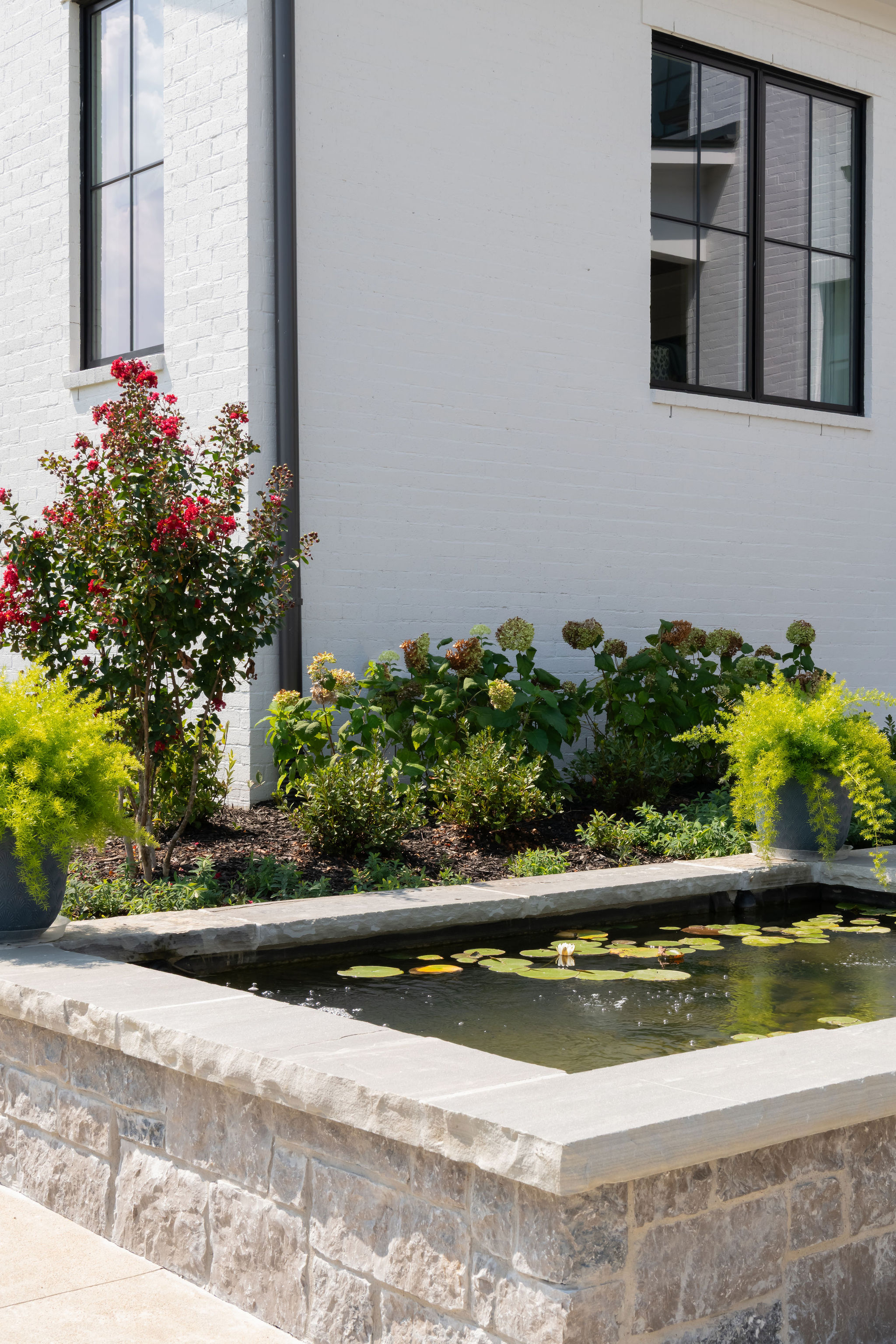 Pond-like water feature with plants in background.